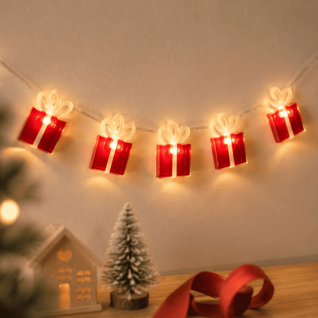 Guirlande de Noël cadeaux de Noël rouge et blanc accroché au mur beige 