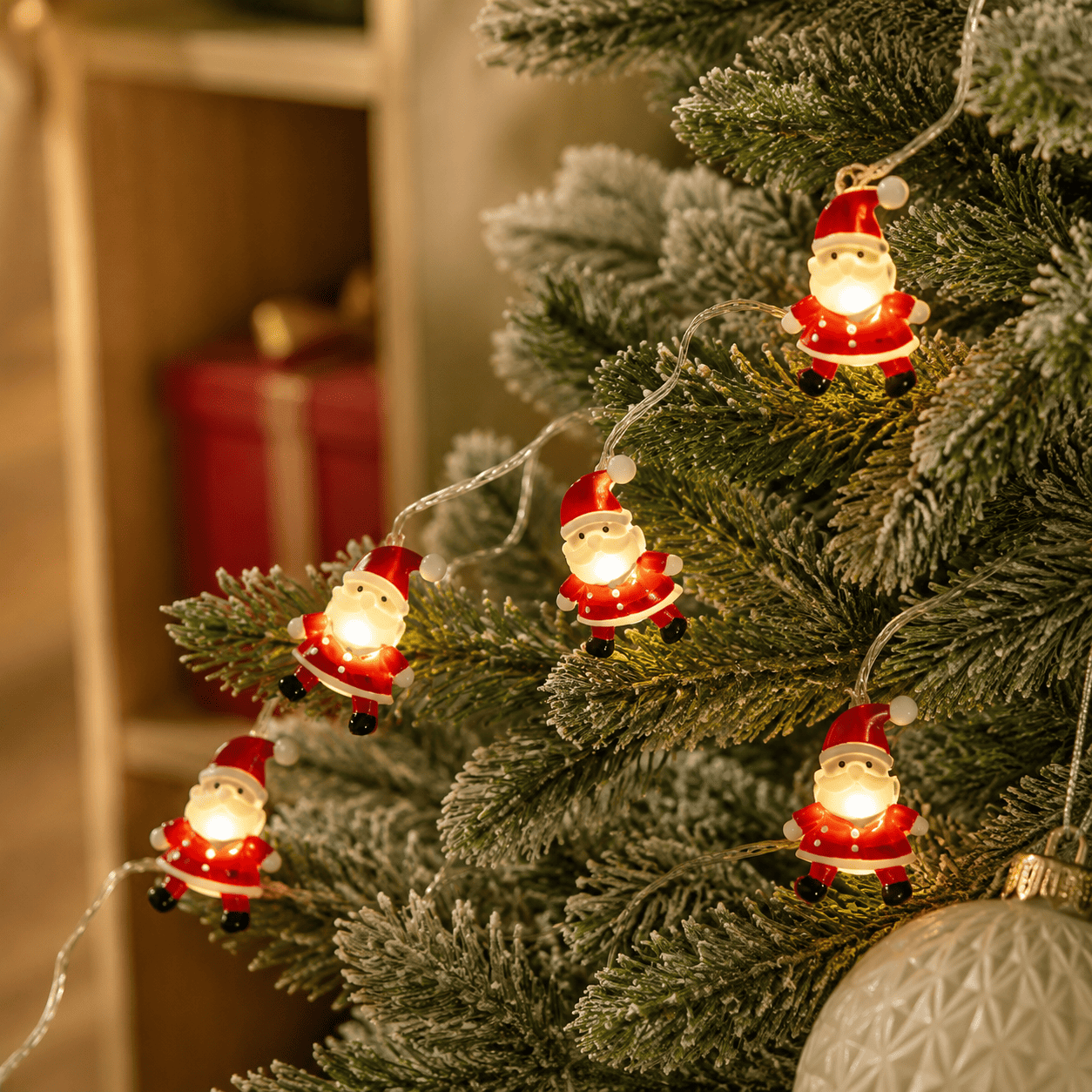 Guirlande lumineuse de Noël pères noël autour du sapin vue de près 