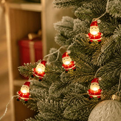 Guirlande lumineuse de Noël pères noël autour du sapin vue de près 