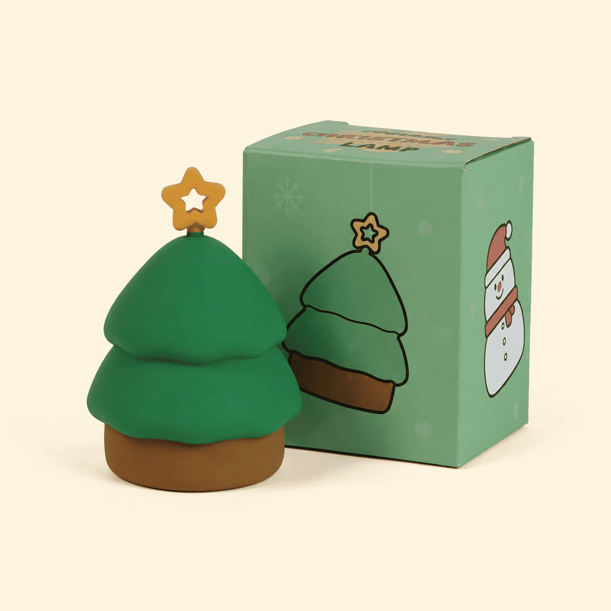Mini veilleuse de Noël en forme de sapin avec sa boîte sur fond beige
